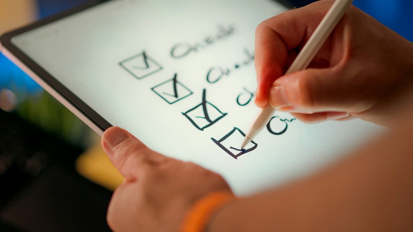 A hand using a stylus to tick the last item on a handwritten checklist on a tablet screen