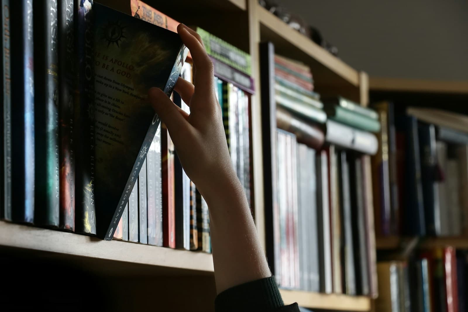 A hand pulling one book from a crowded shelf, the way retrieval picks the right passage for a question