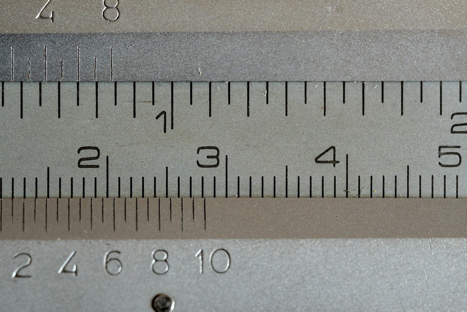 A close-up of an engraved steel ruler with millimetre and centimetre markings